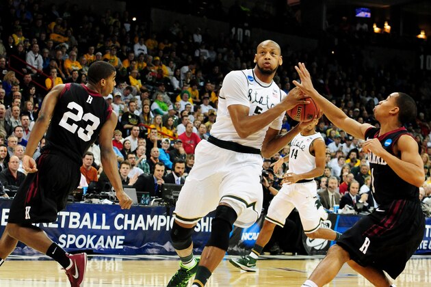 SPOKANE, WA - MARCH 22:  Adreian Payne #5 of the Michigan State Spartans drives between Siyani Chambers #1 and Wesley Saunders #23 of the Harvard Crimson in the first half during the Third Round of the 2014 NCAA Basketball Tournament at Spokane Veterans Memorial Arena on March 22, 2014 in Spokane, Washington.  (Photo by Steve Dykes/Getty Images)
