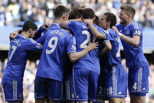 Chelsea's Mohamed Salah, hidden, is surrounded by team mates as he celebrates scoring a goal during the English Premier League soccer match between Chelsea and Arsenal at Stamford Bridge stadium in London, Saturday, March 22, 2014. (AP Photo/Kirsty Wigglesworth)