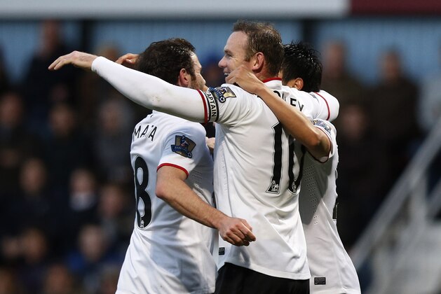 Manchester United's Wayne Rooney, center, celebrates his second goal against West Ham United with teammates during their English Premier League soccer match at Upton Park, London, Saturday, March 22, 2014. (AP Photo/Sang Tan)