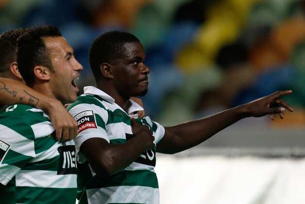 Sporting's William Carvalho, right, celebrates after scoring the opening goal against Pacos de Ferreira during their Portuguese league soccer match Sunday, Dec. 1, 2013, at Sporting's Alvalade stadium in Lisbon. (AP Photo/Armando Franca)