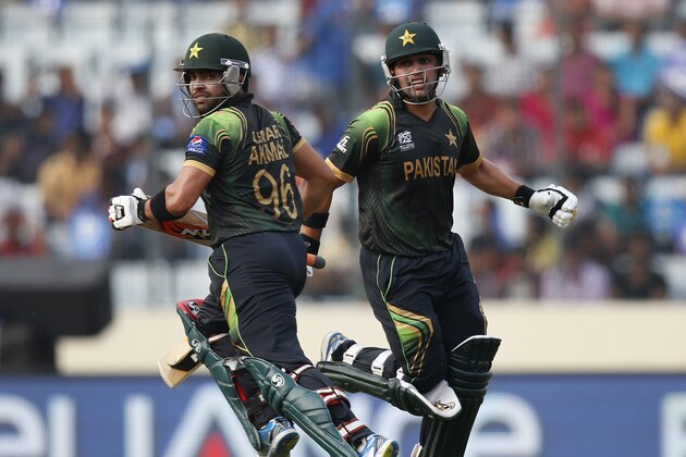 Pakistan's batsmen Umar Akmal, left, and Kamran Akmal run between the wickets to add runs during their ICC Twenty20 Cricket World Cup match against Australia in Dhaka, Bangladesh, Sunday, March 23, 2014. (AP Photo/Aijaz Rahi)
