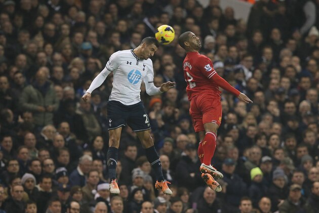 Tottenham's Nacer Chadli, left, heads the ball with Liverpool's Glen Johnson during their English Premier League soccer match between Tottenham Hotspur and Liverpool at the White Hart Lane stadium in London Sunday, Dec  15,  2013. (AP Photo/Alastair Grant)