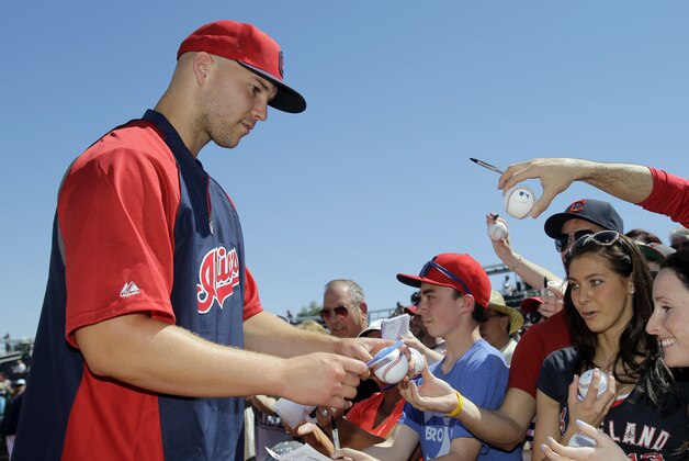 Cleveland Indians' Justin Masterson signs for fans before a spring exhibition baseball game against the Colorado Rockies Saturday, March 22, 2014, in Goodyear, Ariz. (AP Photo/Mark Duncan)