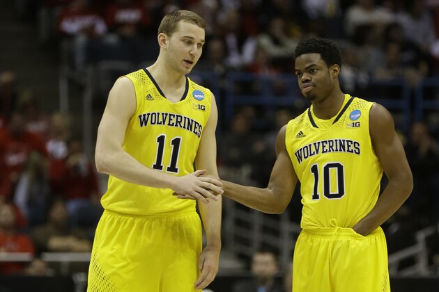 Michigan guards Nik Stauskas (11) and  Derrick Walton Jr. (10) talk during the second half of a third-round game of the NCAA college basketball tournament Saturday, March 22, 2014, in Milwaukee. (AP Photo/Jeffrey Phelps)