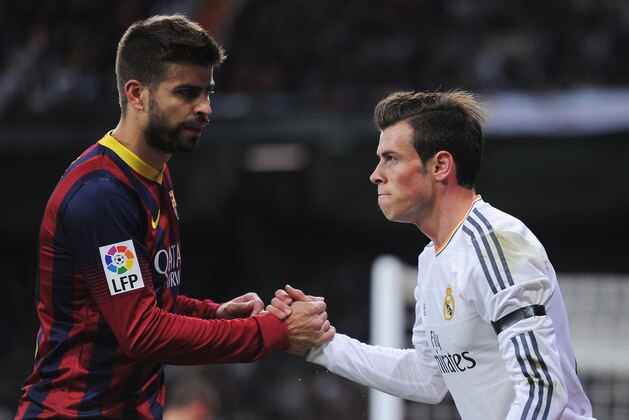 MADRID, SPAIN - MARCH 23:  Gerard Pique (L) of Barcelona shakes hands with Gareth Bale of Real Madrid during the La Liga match between Real Madrid CF and FC Barcelona at the Bernabeu on March 23, 2014 in Madrid, Spain.  (Photo by Denis Doyle/Getty Images)