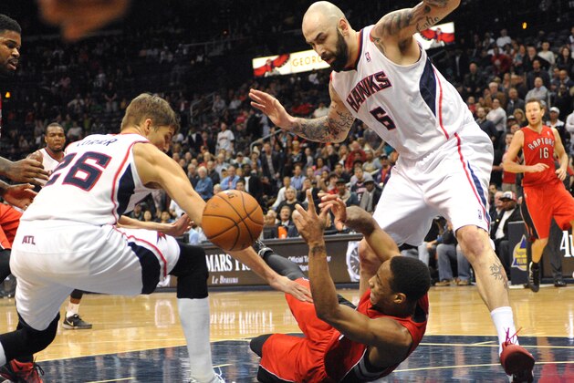 Toronto Raptors guard DeMar DeRozan, center, tries to control the rebound in front of Atlanta Hawks guard Kyle Korver (26) and Atlanta Hawks center Pero Antic (6) in the second half of their NBA basketball game Tuesday, March 18, 2014, in Atlanta. Atlanta won 118-113 in overtime. (AP Photo/David Tulis)