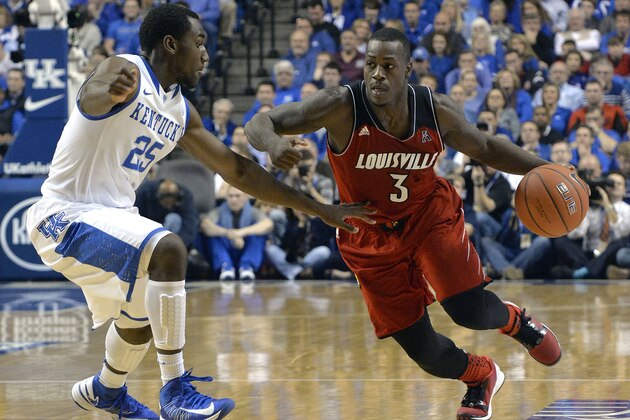 Louisville's Chris Jones, right, attempts to drive past the defense of Kentucky's Dominique Hawkins during the first half of an NCAA college basketball game Saturday Dec. 28, 2013, in Lexington, Ky. (AP Photo/Timothy D. Easley)