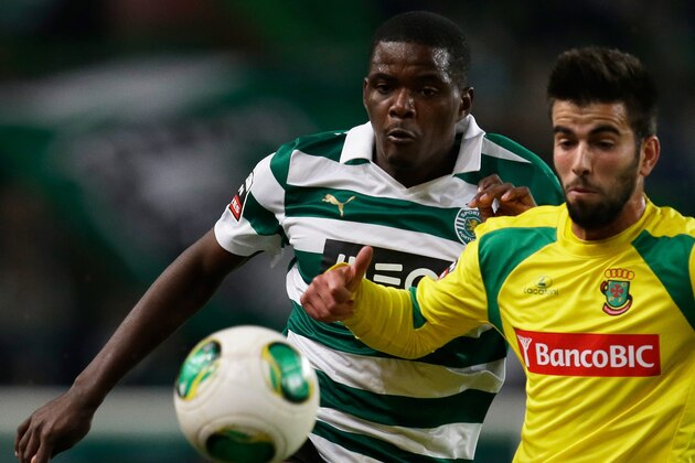 Sporting's William Carvalho, left, fights for the ball with Pacos de Ferreira's Sergio Oliveira  during their Portuguese league soccer match Sunday, Dec. 1, 2013, at Sporting's Alvalade stadium in Lisbon. (AP Photo/Armando Franca)