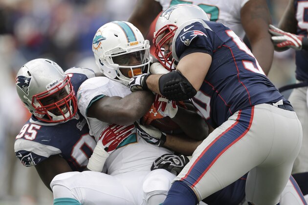 New England Patriots defensive ends Chandler Jones (95) and Rob Ninkovich (50) tackle Miami Dolphins running back Lamar Miller, center, in the third quarter of an NFL football game Sunday, Oct. 27, 2013, in Foxborough, Mass. (AP Photo/Steven Senne)