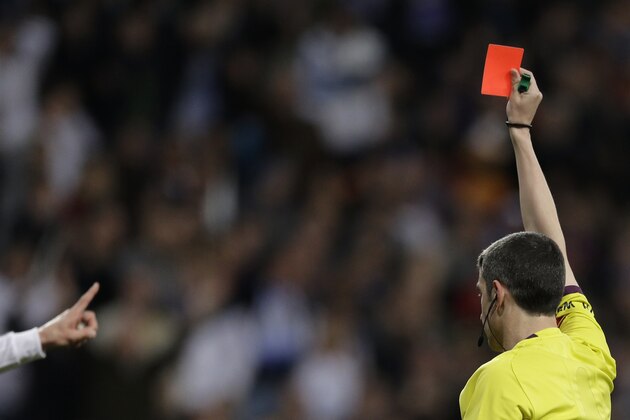Real Madrid's Sergio Ramos, left disputes a red card shown to him by the referee for a foul on FC Barcelona's Neymar during a Spanish La Liga soccer match at the Santiago Bernabeu stadium in Madrid, Sunday March 23, 2014. (AP Photo/Paul White)