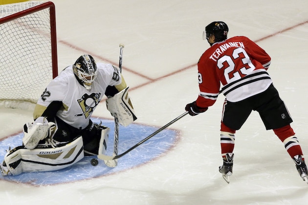 Pittsburgh Penguins goalie Tomas Vokoun, left, blocks a shot by Chicago Blackhawks' Teuvo Teravainen during a shootout in a preseason NHL hockey game in Chicago, Thursday, Sept. 19, 2013. The Penguins won 4-3. (AP Photo/Nam Y. Huh)