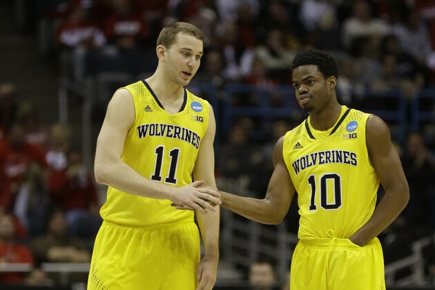 Michigan guards Nik Stauskas (11) and  Derrick Walton Jr. (10) talk during the second half of a third-round game of the NCAA college basketball tournament Saturday, March 22, 2014, in Milwaukee. (AP Photo/Jeffrey Phelps)
