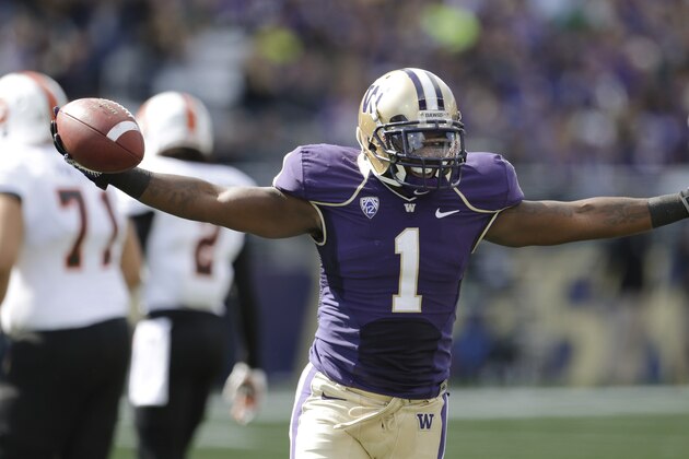 Washington safety Sean Parker raises his arms as he runs off the field after intercepting an Idaho State pass in the first half of an NCAA college football game Saturday, Sept. 21, 2013, in Seattle. (AP Photo/Elaine Thompson)