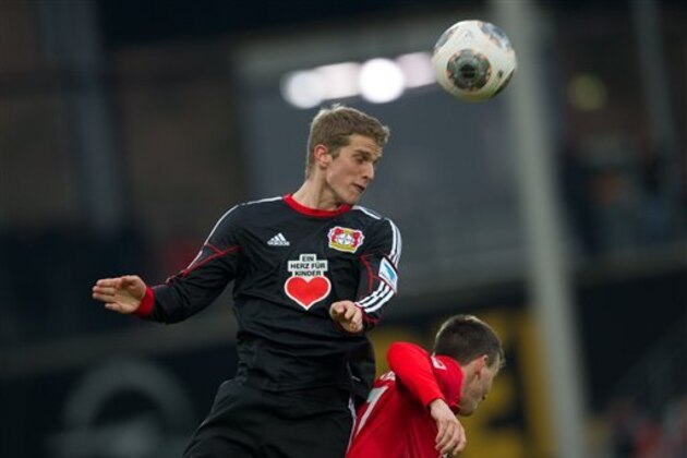 Leverkusen's  Lars Bender, left, challenges for the ball with  Freiburg's Vladimir Darida. during the German Bundesliga soccer match between SC Freiburg and Bayer Leverkusen in Freiburg, Germany, Saturday Jan. 25, 2014.  (AP Photo/dpa,Uwe Anspach)