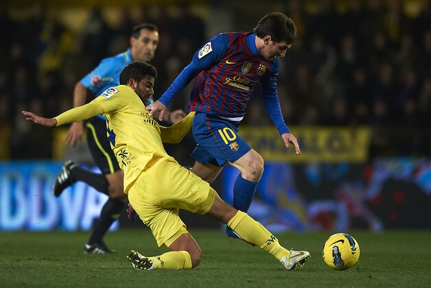 VILLARREAL, SPAIN - JANUARY 28:  Mateo Musacchio (L) of Villarreal competes for the ball with Lionel Messi of Barcelona during the la Liga match between Villarreal and Barcelona at El Madrigal on January 28, 2012 in Villarreal, Spain.  (Photo by Manuel Queimadelos Alonso/Getty Images)