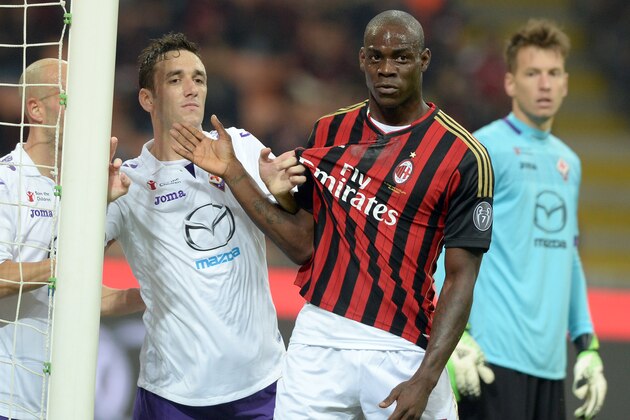 MILAN, ITALY - NOVEMBER 02:  Mario Balotelli of AC Milan #45 and Gonzalo Rodriguez of ACF Fiorentina during the Serie A match between AC Milan and ACF Fiorentina at Stadio Giuseppe Meazza on November 2, 2013 in Milan, Italy.  (Photo by Claudio Villa/Getty Images)