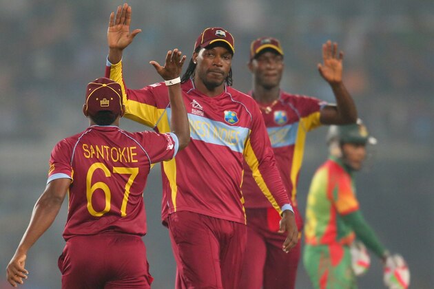 DHAKA, BANGLADESH - MARCH 25:  Krishmar Santokie of the West Indies is congratulated by Chris Gayle and after Darren Sammy taking a catch to dismiss Mominul Haque of Bangladesh during the ICC World Twenty20 Bangladesh 2014 match between Bangladesh and the West Indies at Sher-e-Bangla Mirpur Stadium on March 25, 2014 in Dhaka, Bangladesh.  (Photo by Scott Barbour/Getty Images)