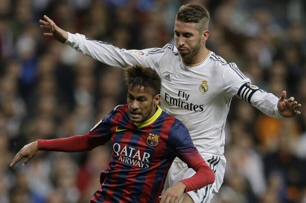 FC Barcelona's Neymar from Brazil, left is pressured by Real Madrid's Sergio Ramos during a Spanish La Liga soccer match at the Santiago Bernabeu stadium in Madrid, Sunday March 23, 2014. (AP Photo/Paul White)