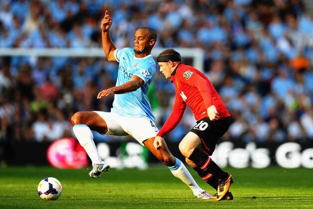 MANCHESTER, ENGLAND - SEPTEMBER 22:  Vincent Kompany of Manchester City battles with Wayne Rooney of Manchester United during the Barclays Premier League match between Manchester City and Manchester United at the Etihad Stadium on September 22, 2013 in Manchester, England.  (Photo by Laurence Griffiths/Getty Images)