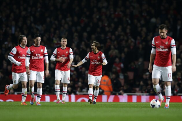 Arsenal's Mathieu Flamini, fourth left, shouts encouragement to his teammates, from left, Tomas Rosicky, Mikel Arteta, Per Mertesacker, and Olivier Giroud as they walk back up the pitch after Swansea City's Wilfried Bony scored during the English Premier League soccer match between Arsenal and Swansea City's at the Emirates Stadium in London, Tuesday, March 25, 2014.  (AP Photo/Matt Dunham)