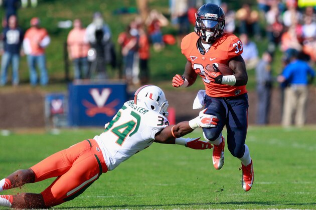 CHARLOTTESVILLE, VA - NOVEMBER 10:  Running back Perry Jones #33 of the Virginia Cavaliers carries the ball as linebacker Thurston Armbrister #34 of the Miami Hurricanes attempts the tackle at Scott Stadium on November 10, 2012 in Charlottesville, Virginia.  (Photo by Geoff Burke/Getty Images)