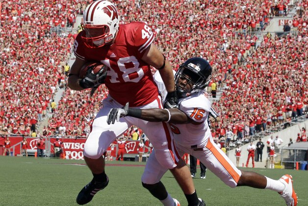 Wisconsin's Jacob Pedersen (48) catches a touchdown pass with Oregon State's Rashaad Reynolds (16) defending during the first half of an NCAA college football game, Saturday, Sept. 10, 2011, in Madison, Wis. (AP Photo/Morry Gash)