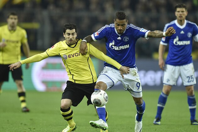 Schalke's Kevin-Prince Boateng of Ghana, right, and Dortmund's Henrikh Mkhitaryan of Armenia challenge for the ball during  the German Bundesliga soccer match between Borussia Dortmund and FC Schalke 04 in Dortmund,  Germany, Tuesday, March 25, 2014. (AP Photo/Martin Meissner)