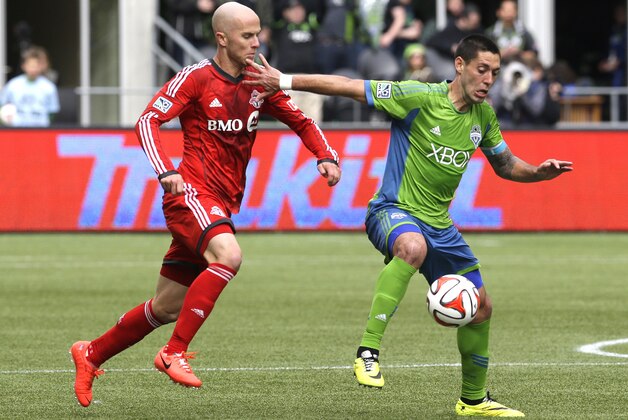 Seattle Sounders' Clint Dempsey, right, tries to hold off Toronto FC's Michael Bradley, left, in the second half of an MLS soccer match on Saturday, March 15, 2014, in Seattle. Toronto won 2-1. (AP Photo/Ted S. Warren)