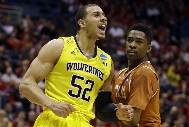 Michigan forward Jordan Morgan (52) reacts to a foul call as Texas guard Isaiah Taylor watches him during the second half of a third-round game of the NCAA college basketball tournament Saturday, March 22, 2014, in Milwaukee. (AP Photo/Jeffrey Phelps)