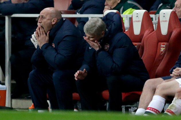 Arsenal's French manager Arsene Wenger, right, rubs his face next to his assistant manager Steve Bould after Swansea City equalized through a Mathieu Flamini own goal to make the final score 2-2 during the English Premier League soccer match between Arsenal and Swansea City at the Emirates Stadium in London, Tuesday, March 25, 2014. (AP Photo/Matt Dunham)