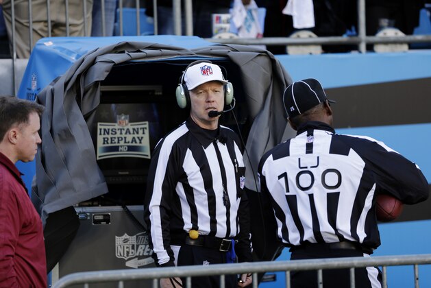 Officials watch an instant replay after a San Francisco 49ers touchdown against the Carolina Panthers during the first half of a divisional playoff NFL football game, Sunday, Jan. 12, 2014, in Charlotte, N.C. (AP Photo/Chuck Burton)