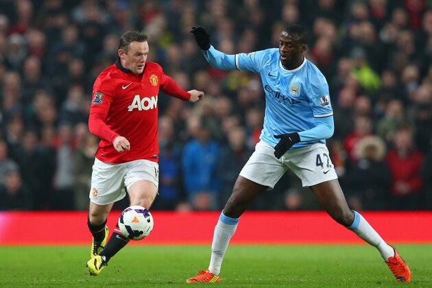 MANCHESTER, ENGLAND - MARCH 25:  Yaya Toure of Manchester City competes with Wayne Rooney of Manchester United during the Barclays Premier League match between Manchester United and Manchester City at Old Trafford on March 25, 2014 in Manchester, England.  (Photo by Alex Livesey/Getty Images)
