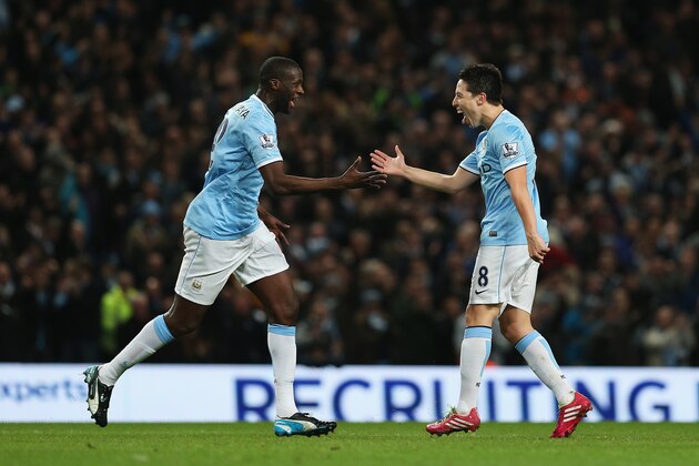 MANCHESTER, ENGLAND - DECEMBER 01:  Samir Nasri (R) of Manchester City celebrates his team's second goal with Yaya Toure during the Barclays Premier League match between Manchester City and Swansea City at Etihad Stadium on December 1, 2013 in Manchester, England.  (Photo by Clive Brunskill/Getty Images)