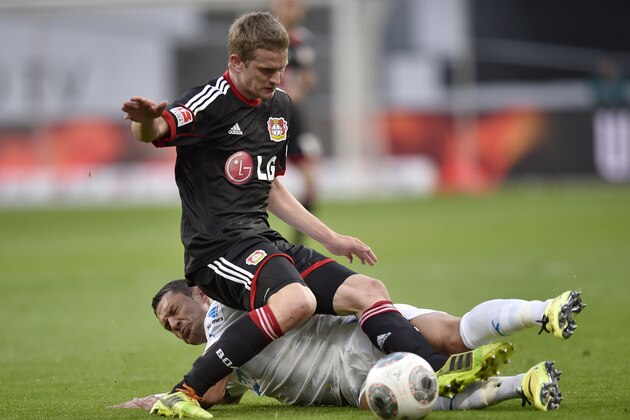 Hoffenheim's Sejad Salihovic of Bosnia, bottom, and Leverkusen's Lars Bender challenge for the ball during  the German Bundesliga soccer match between Bayer Leverkusen and 1899 Hoffenheim in Leverkusen,  Germany, Sunday, March 23, 2014. (AP Photo/Martin Meissner)