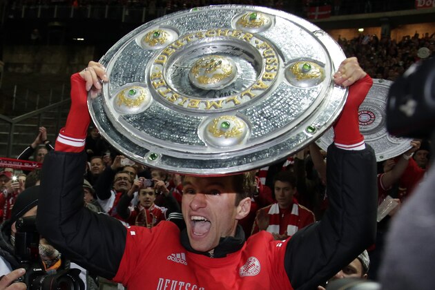 Bayern's Thomas Mueller lifts a mock champions trophy after the German Bundesliga soccer match between Hertha BSC Berlin and Bayern Munich in Berlin, Germany, Tuesday, March 25, 2014. (AP Photo/Michael Sohn)