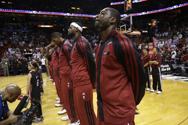 Miami Heat's Chris Bosh, left, LeBron James, center, and Dwyane Wade, right, stand for the national anthem before an NBA basketball game against the Sacramento Kings, Friday, Dec. 20, 2013, in Miami. (AP Photo/Lynne Sladky)