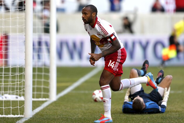 New York Red Bulls forward Thierry Henry, front, celebrates after scoring a goal on Colorado Rapids goalkeeper John Berner during the second half of an MLS soccer game, Saturday, March 15, 2014, in Harrison, N.J. The teams tied 1-1. (AP Photo/Julio Cortez)