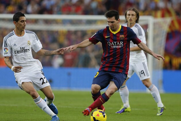 Barcelona's Lionel Messi from Argentina controls the ball past Real Madrid's Angel Di Maria from Argentina during a Spanish La Liga soccer match between Barcelona F.C. and Real Madrid at the Camp Nou stadium in Barcelona, Spain, Saturday Oct. 26, 2013. (AP Photo/Emilio Morenatti)