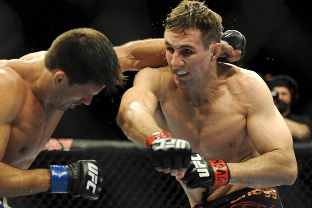 Feb 22, 2014; Las Vegas, NV, USA;  Rory MacDonald (red gloves) throws a punch at Demian Maia (blue gloves) during their UFC welterweight bout at Mandalay Bay. MacDonald won by way of a 29-28 decision. Mandatory Credit: Stephen R. Sylvanie-USA TODAY Sports