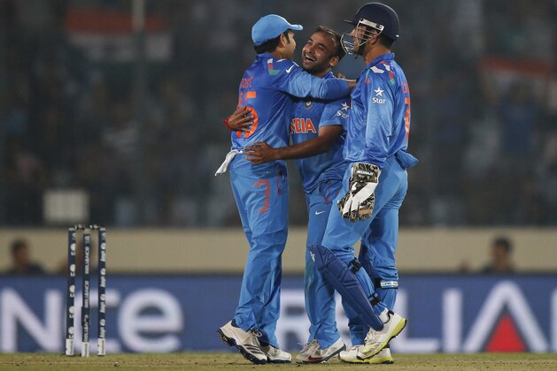 India's bowler Amit Mishra, center, celebrates with captain Mahendra Singh Dhoni, right, and teammate Rohit Sharma after taking the wicket of West Indies' batsman Dwayne Bravo during their ICC Twenty20 Cricket World Cup match in Dhaka, Bangladesh, Sunday, March 23, 2014. (AP Photo/Aijaz Rahi)