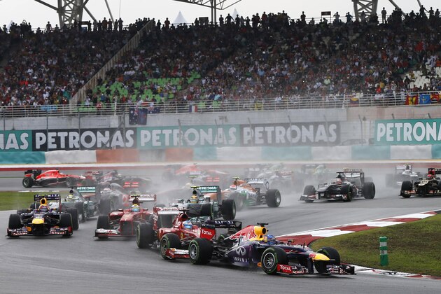 Red Bull driver Sebastian Vettel of Germany, right, leads the pack during the Malaysian Formula One Grand Prix at Sepang, Malaysia, Sunday, March 24, 2013. (AP Photo/Vincent Thian)