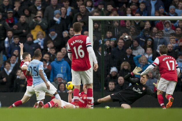 Manchester City's Fernandinho, second left, scores past Arsenal's goalkeeper Wojciech Szczesny, centre right, during their English Premier League soccer match at the Etihad Stadium, Manchester, England, Saturday Dec. 14, 2013. (AP Photo/Jon Super)