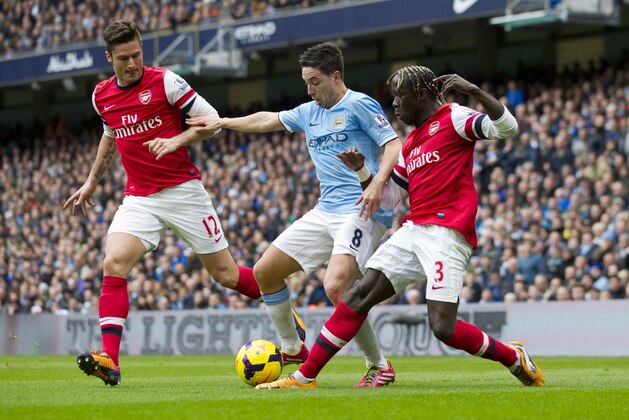Manchester City's Samir Nasri, center, fights for the ball with Arsenal's Olivier Giroud, left, and Bacary Sagna during their English Premier League soccer match at the Etihad Stadium, Manchester, England, Saturday Dec. 14, 2013. (AP Photo/Jon Super)