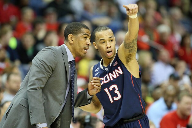 Mar 15, 2014; Memphis, TN, USA; Connecticut Huskies head coach Kevin Ollie talks to guard Shabazz Napier (13) during the first half against the Louisville Cardinals in final of the American Athletic Conference college basketball tournament at FedEx Forum. Mandatory Credit: Nelson Chenault-USA TODAY Sports