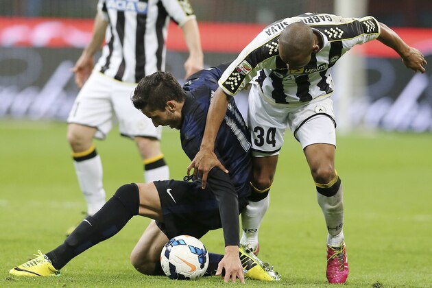 Inter Milan midfielder Ricardo Alvarez, left, of Argentina, challenges for the ball with Udinese Brazilian defender Gabriel Da Silva during the Serie A soccer match between Inter Milan and Udinese at the San Siro stadium in Milan, Italy, Thursday, March 27, 2014. (AP Photo/Antonio Calanni)