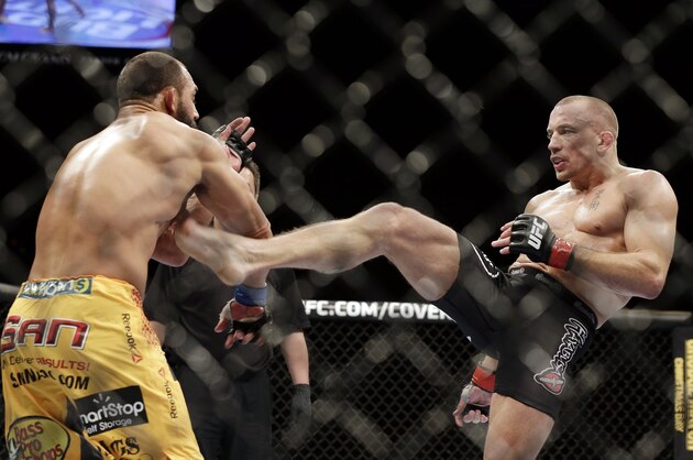 Georges St. Pierre, of Canada, right, kicks Johny Hendricks during a UFC 167 mixed martial arts championship welterweight bout on Saturday, Nov. 16, 2013, in Las Vegas. St. Pierre won by split decision. (AP Photo/Isaac Brekken)
