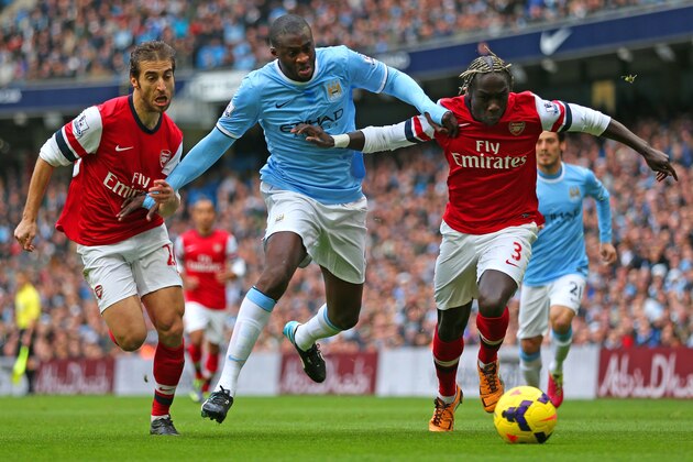 MANCHESTER, ENGLAND - DECEMBER 14: Yaya Toure of Manchester City is closed down by Mathieu Flamini and Bacary Sagna of Arsenal during the Barclays Premier League match between Manchester City and Arsenal at Etihad Stadium on December 14, 2013 in Manchester, England. (Photo by Clive Brunskill/Getty Images) MANCHESTER, ENGLAND - DECEMBER 14: Yaya Toure of Manchester City is closed down by Mathieu Flamini and Bacary Sagna of Arsenal during the Barclays Premier League match between Manchester City and Arsenal at Etihad Stadium on December 14, 2013 in Manchester, England. (Photo by Clive Brunskill/Getty Images)