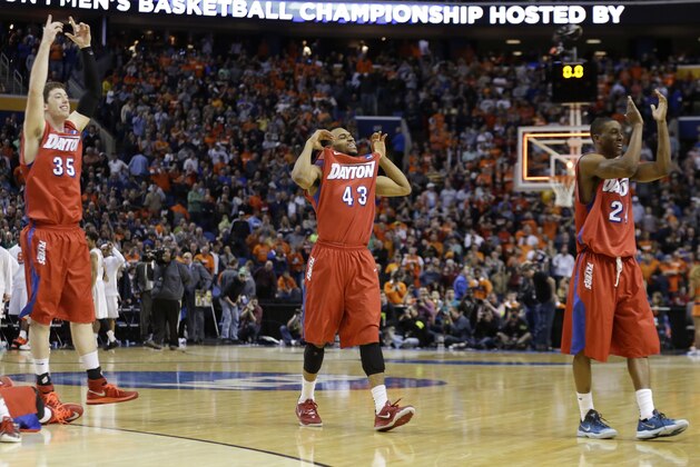 Dayton's Matt Kavanaugh (35), Vee Sanford (43) and Jordan Sibert (24) celebrate during the second half of a third-round game against Syracuse in the NCAA men's college basketball tournament in Buffalo, N.Y., Saturday, March 22, 2014. Dayton won 55-53. (AP Photo/Frank Franklin II)