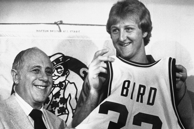 Former Indiana State basketball star Larry Bird displays his new Celtics uniform bearing the number 33, assisted by Celtics President Red Auerbach, left, at a news conference in Boston on Friday, June 8, 1979. The 6-foot-9 Bird became the richest rookie in sports history when he signed a Celtics contact calling for $3.25 million over five years. (AP Photo/Liss)
