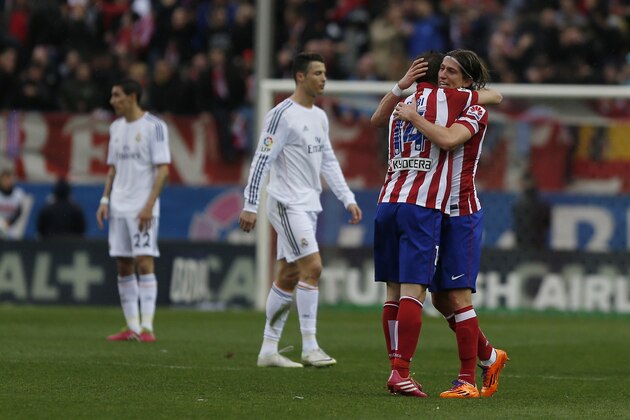 Atletico's Gabi, centre, celebrates his goal with teammate Filipe Luis, right, next to Real's Cristiano Ronaldo, second left,  during a Spanish La Liga soccer match between Atletico de Madrid and Real Madrid at the Vicente Calderon stadium in Madrid, Spain, Sunday, March 2, 2014. (AP Photo/Andres Kudacki)